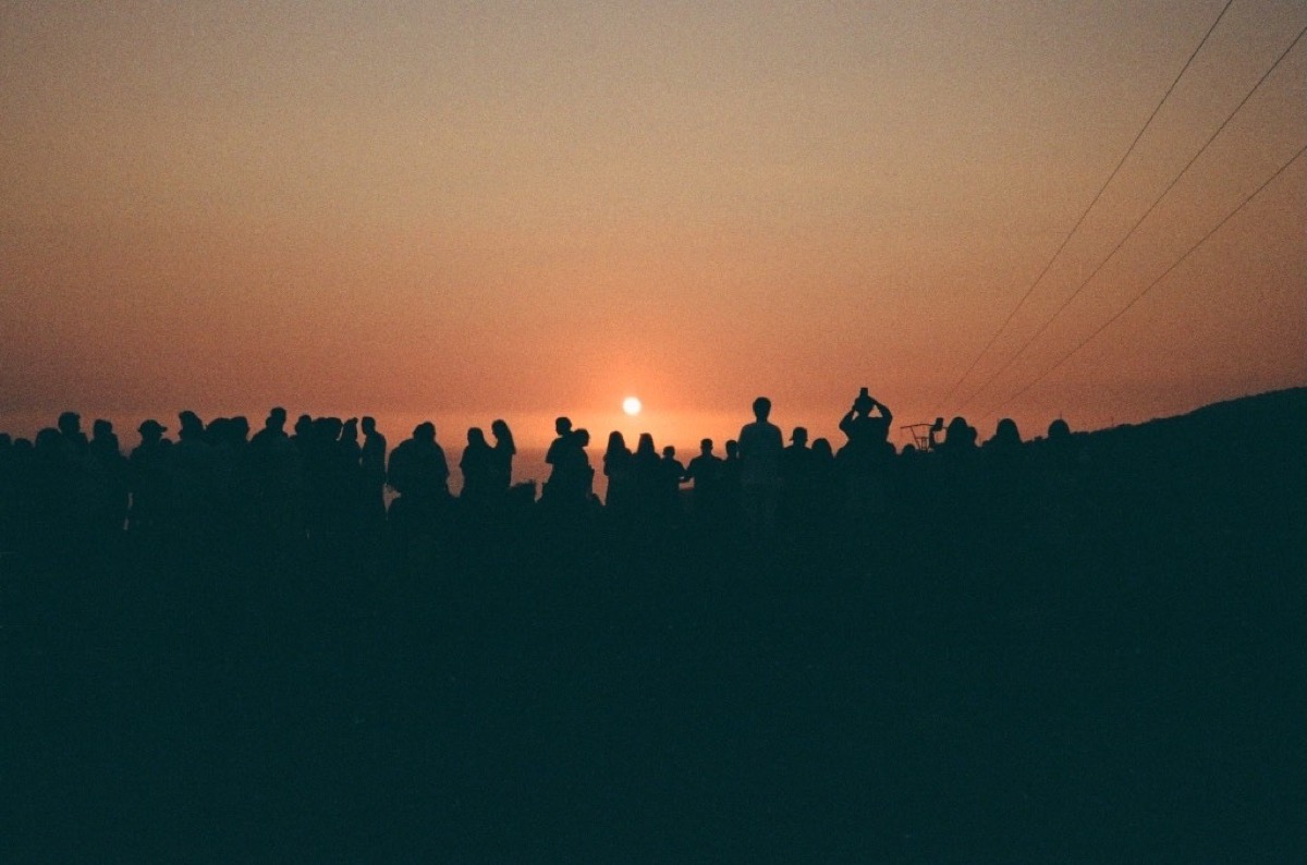 Silhouetted crowd watching sunset in Agadir, Morocco - Travel photography by Rocco Goldschmidt