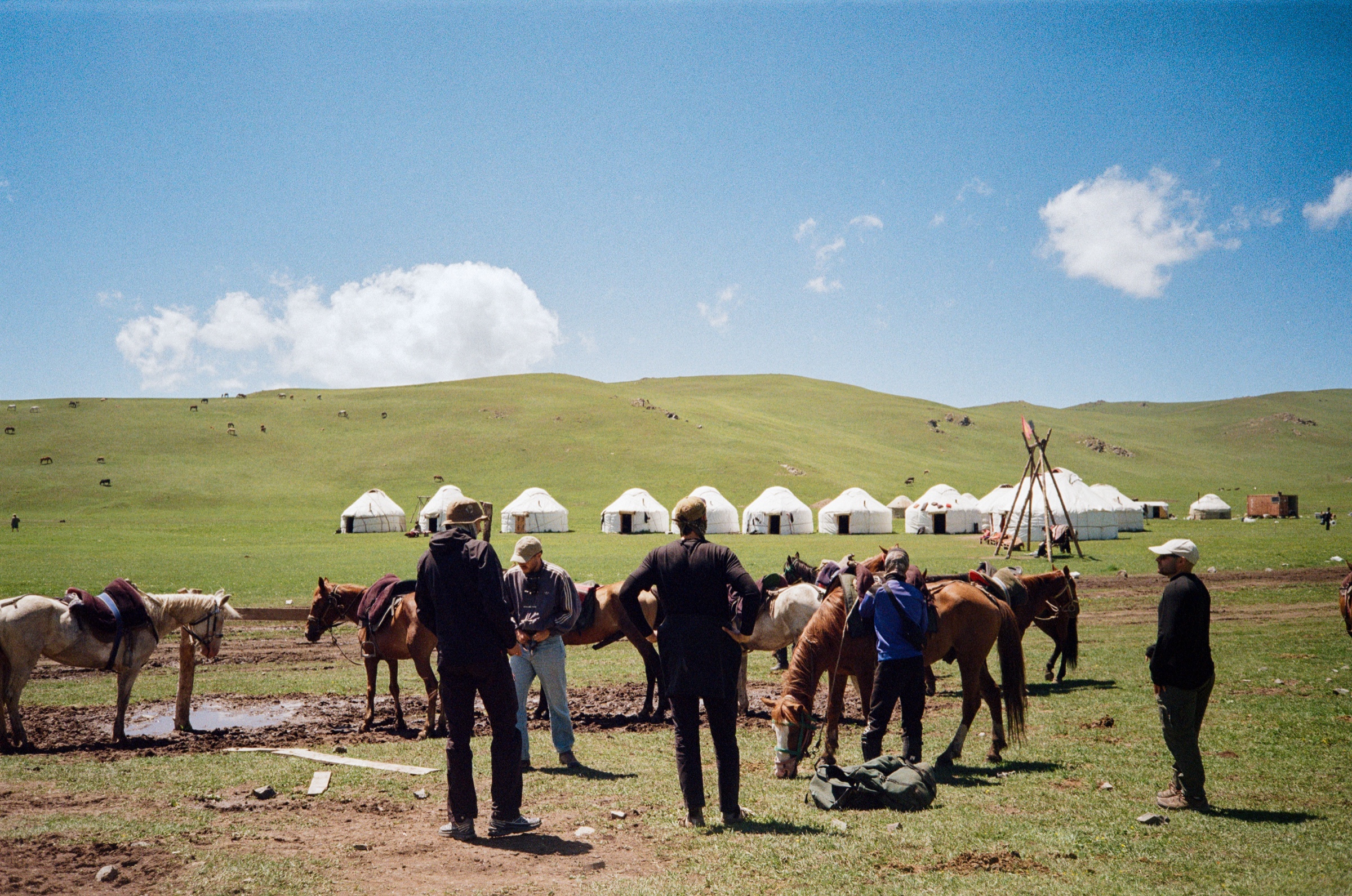 Yurt camp with horses and travellers on the grasslands of Song-Köl, Kyrgyzstan - Travel photography by Rocco Goldschmidt