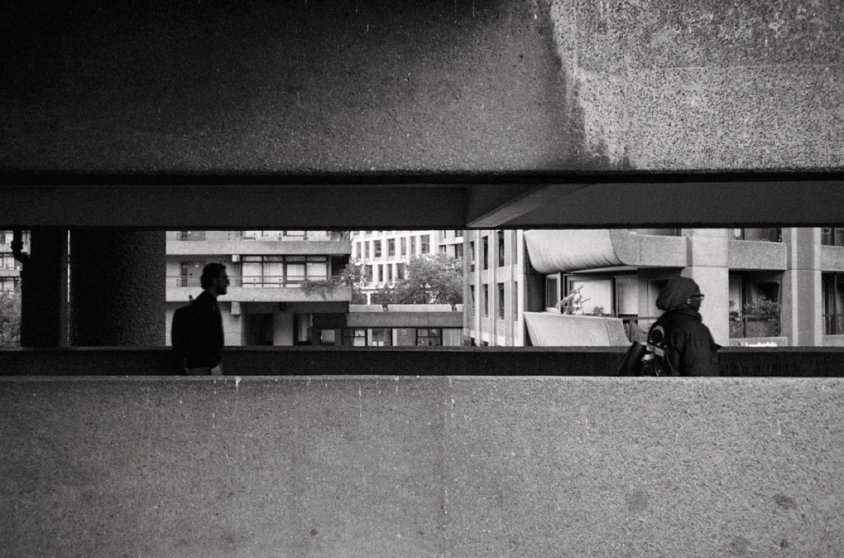 Barbican Estate walkway framed by concrete beams in London, United Kingdom - Black and white architecture photography by Rocco Goldschmidt
