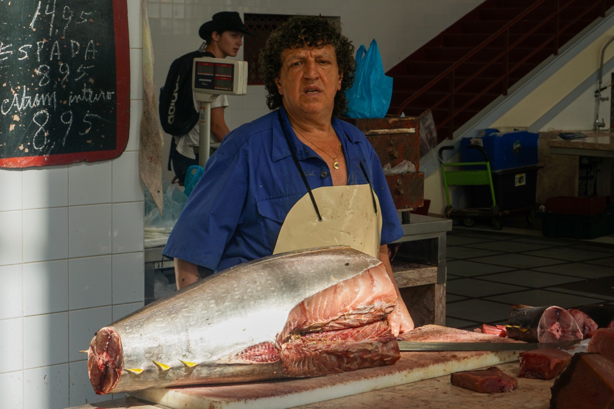 Fishmonger with fresh catch at market in Madeira, Portugal - Street photography by Rocco Goldschmidt