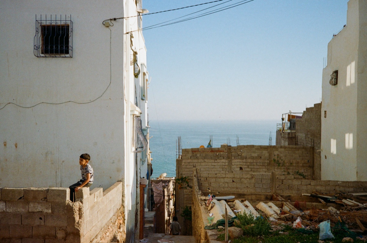 Colourful laundry hanging between trees in an open square in Tamraght, Morocco - Street photography by Rocco Goldschmidt