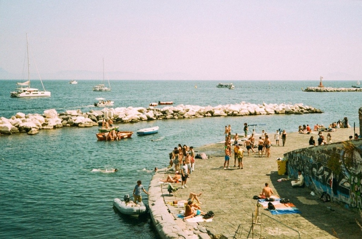 Coastal harbour with boats and sunbathers on the stone pier in Napoli, Italy - Travel photography by Rocco Goldschmidt
