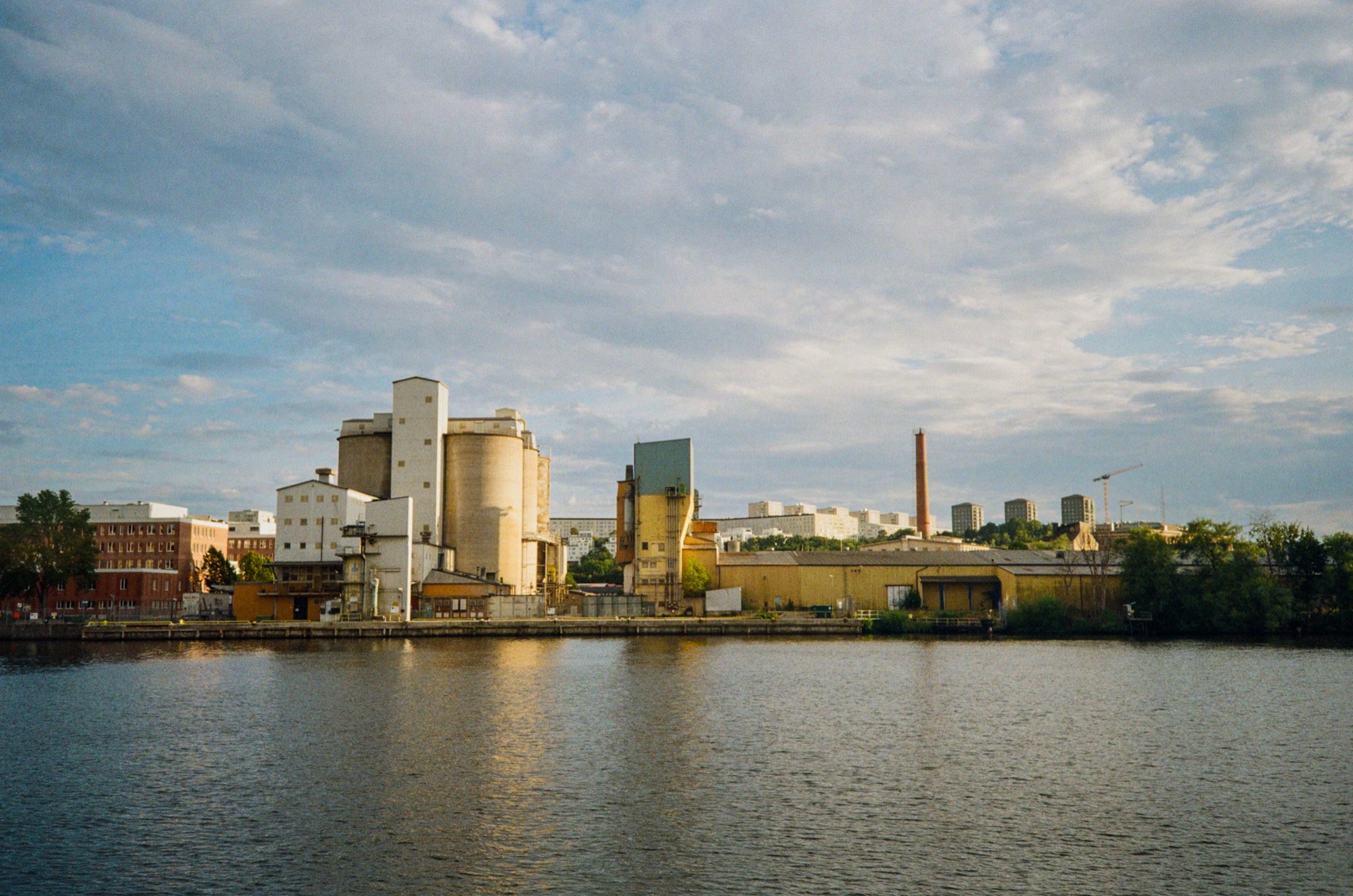 Silos and warehouses along the water under evening light in Stockholm, Sweden - Urban landscape photography by Rocco Goldschmidt