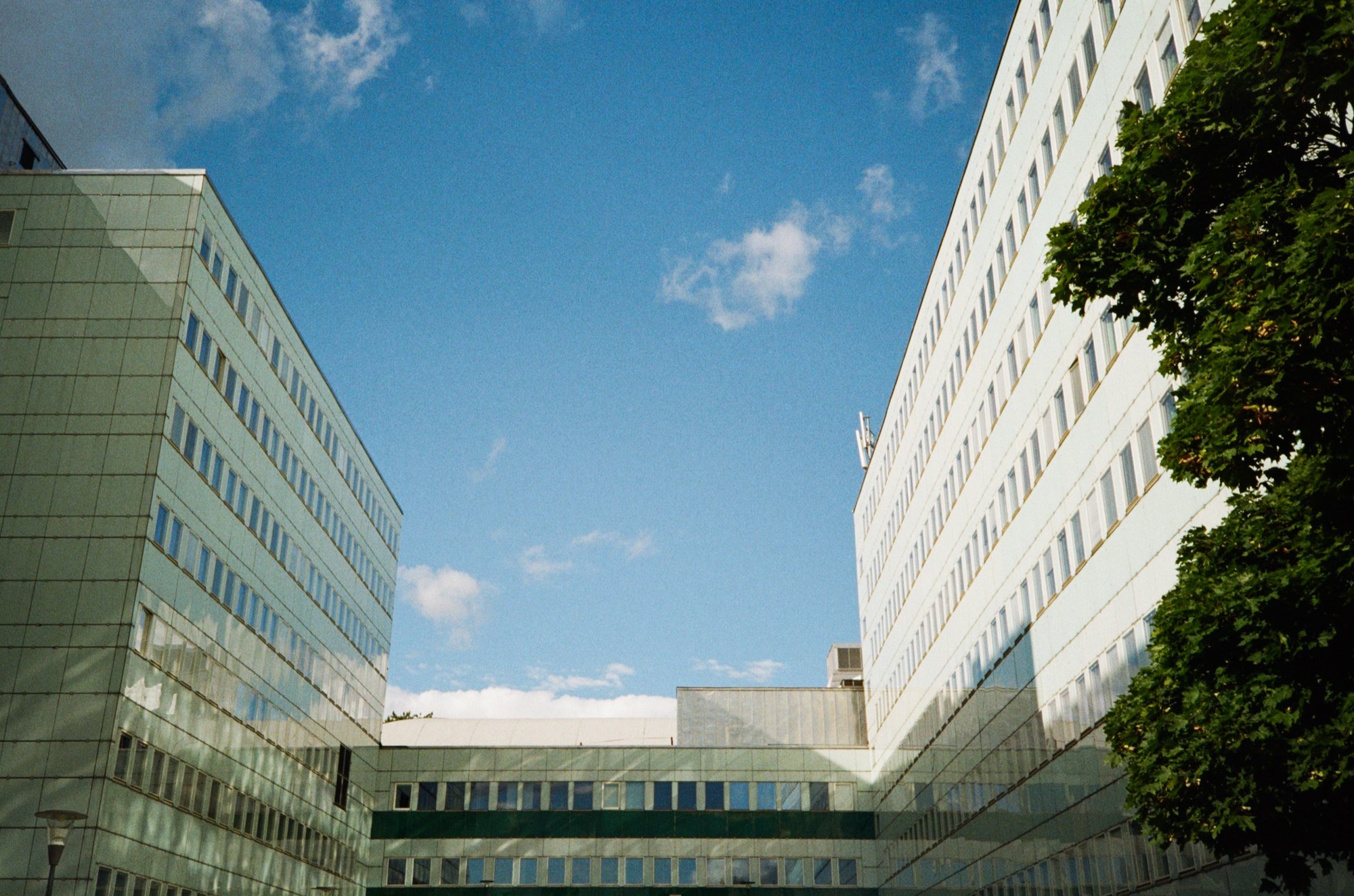 Two modernist office facades converging on a strip of blue sky in Stockholm, Sweden - Architecture photography by Rocco Goldschmidt